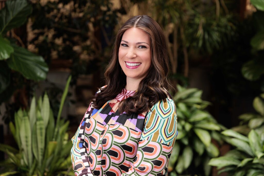 woman outdoor headshot smiling with greenery