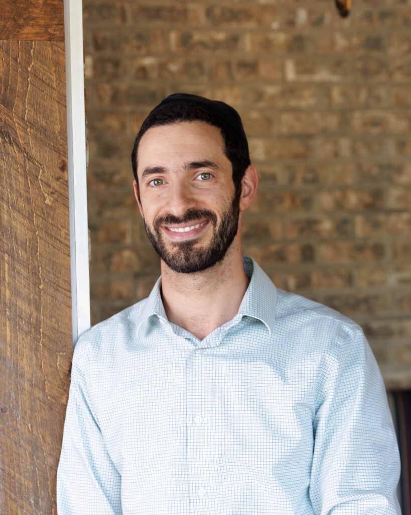 business headshot man smiling brick wall