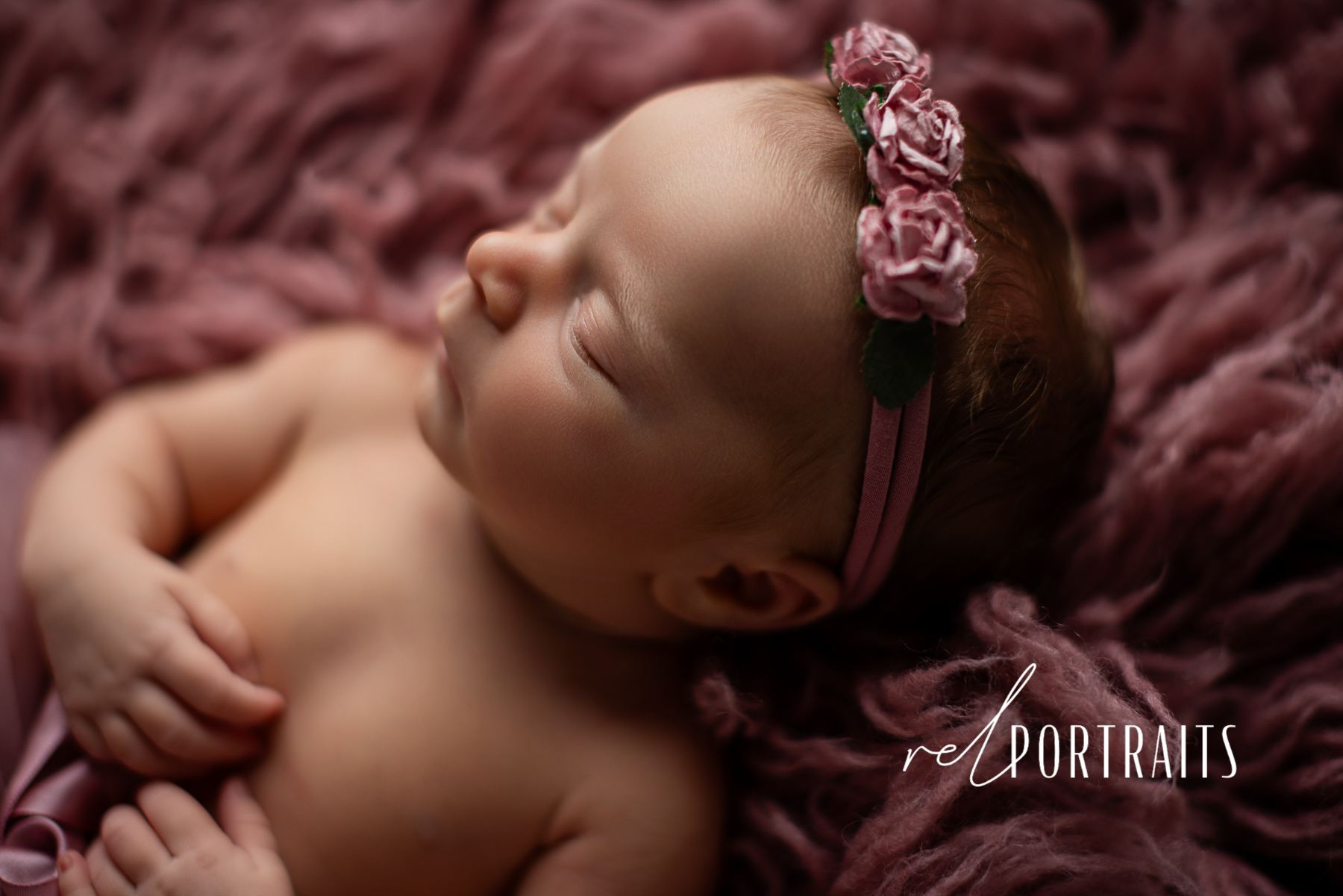 Newborn baby girl in pink in photography studio
