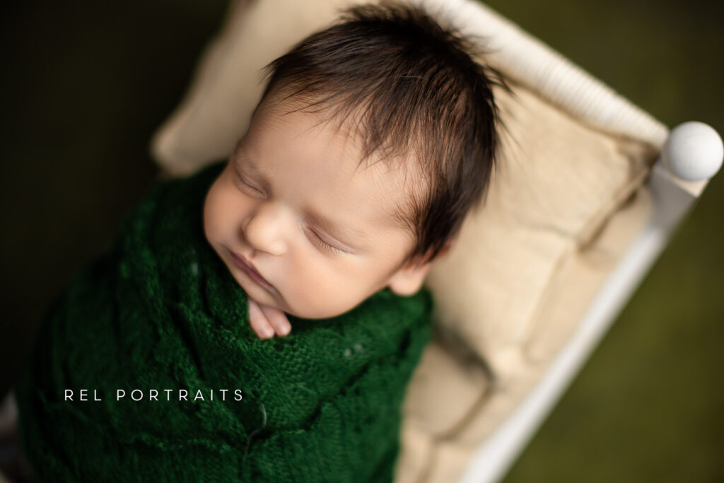 photography close up of Newborn baby boy - in bed wrapped in green