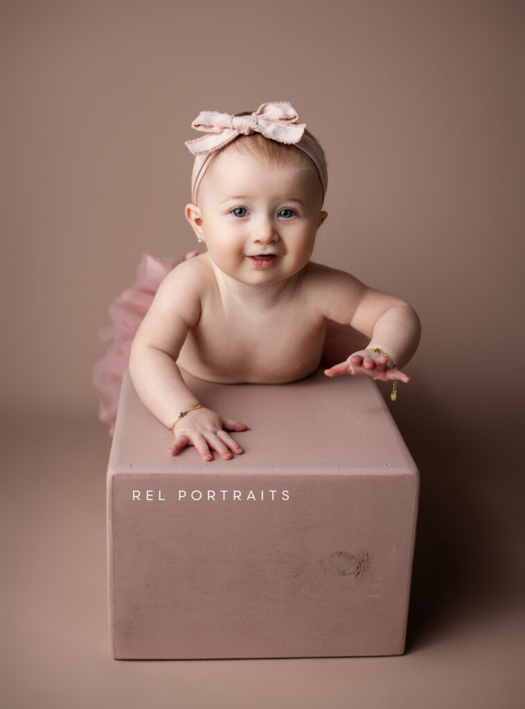 Baby Milestone adorable baby smiling on a box in pink