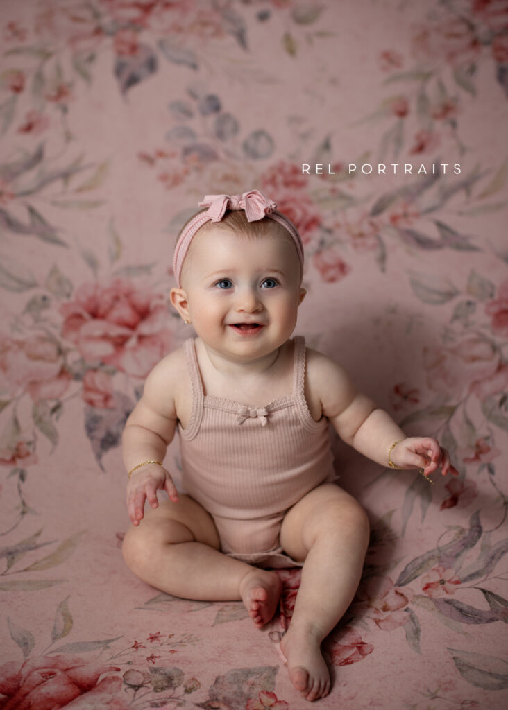 milestone image of baby girl in pink smiling