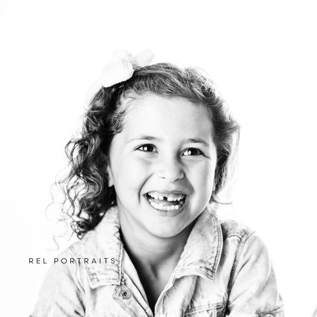 little girl grinning in black and white