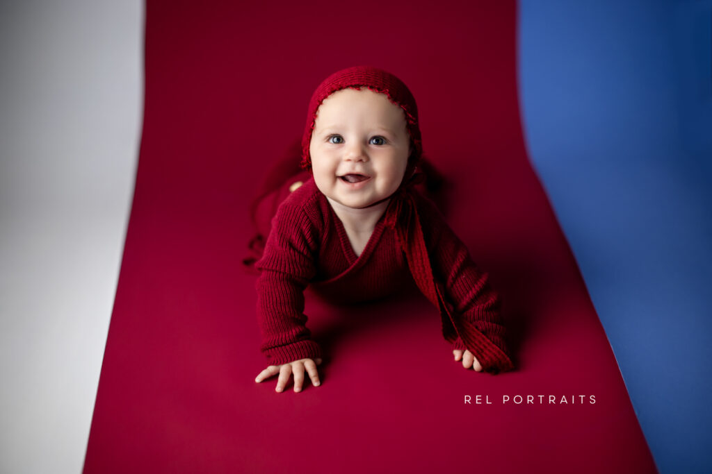 baby grinning in bonnet all in red