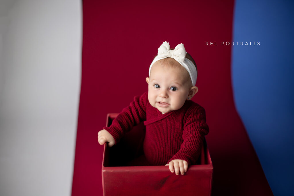 baby making funny face in a box portrait