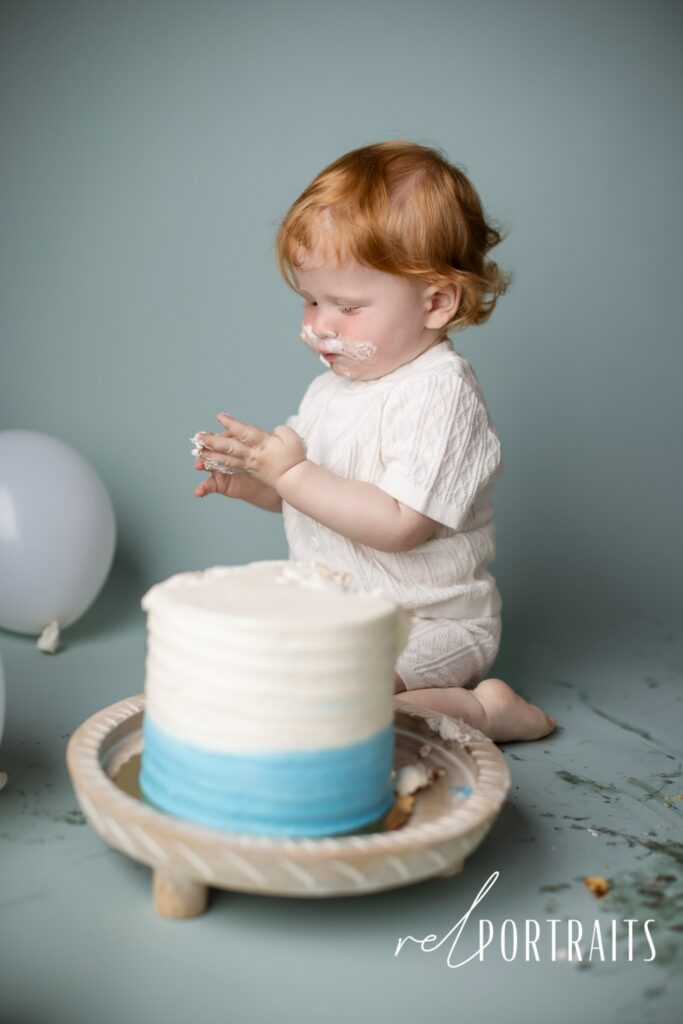 baby boy in blue with cake