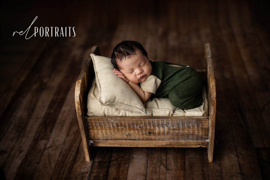 chicago photoshoot of cute newborn baby boy in a wood bed