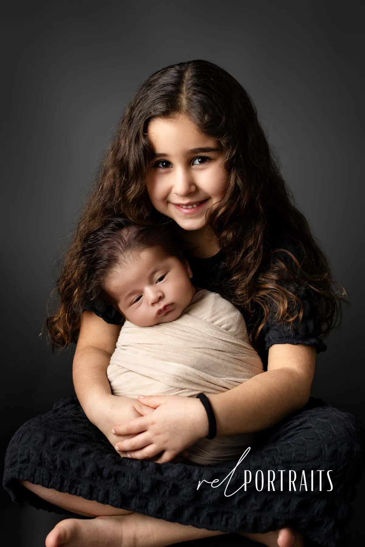 sister holding newborn baby
