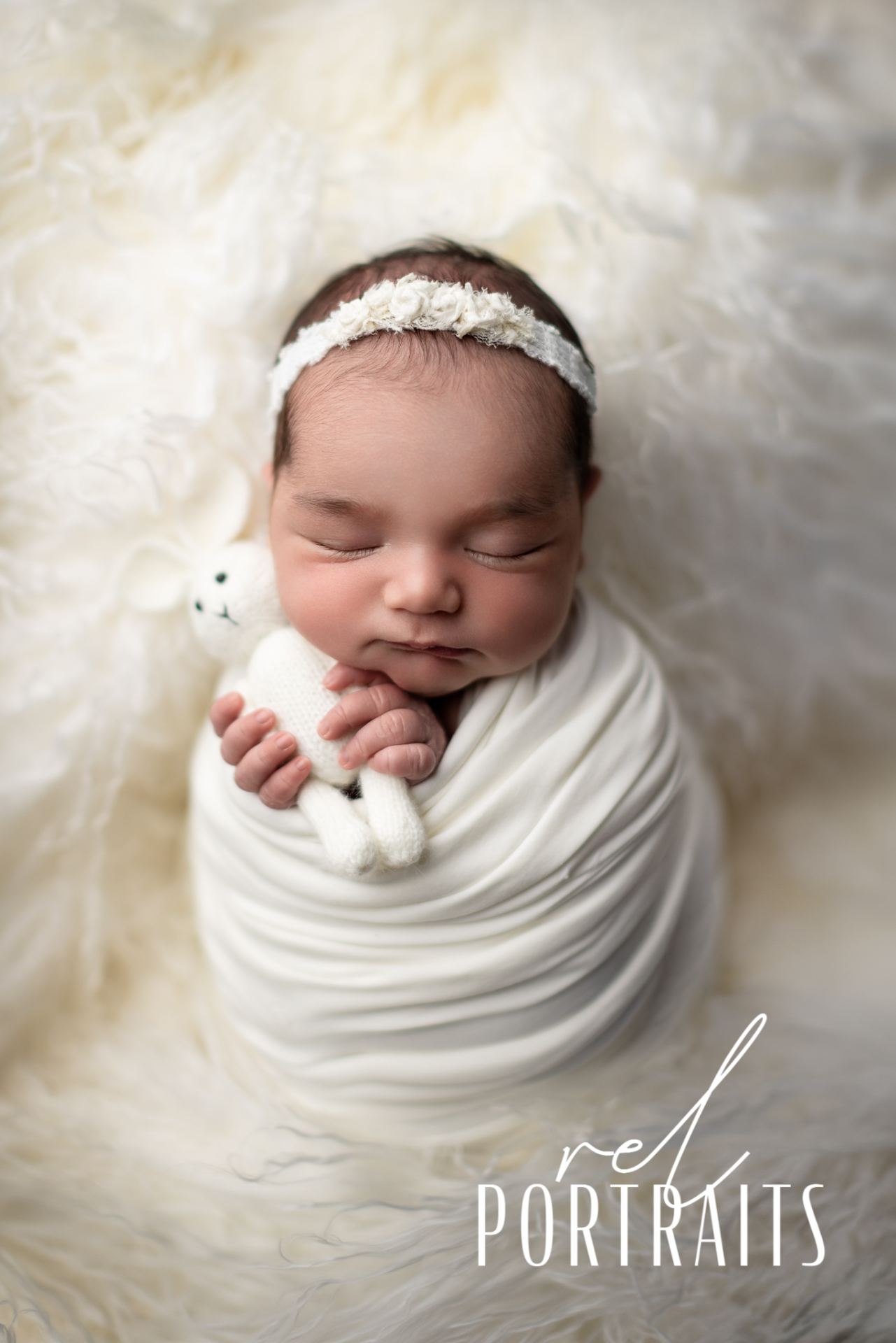 Newborn Baby in White holding a bunny