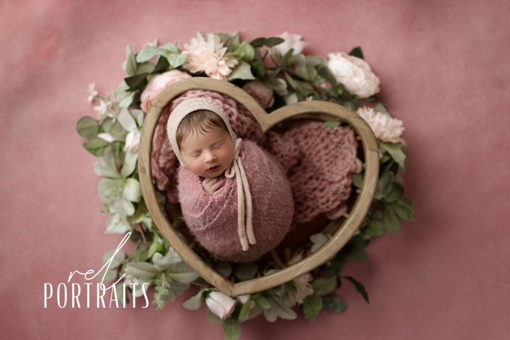 Newborn baby girl in pink heart